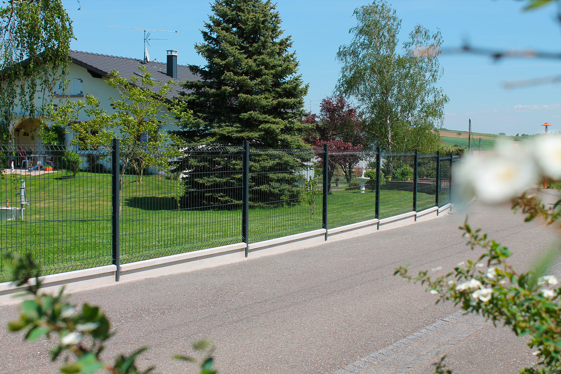 Délimitation d'une résidence individuelle avec clôture en panneaux et dalles béton