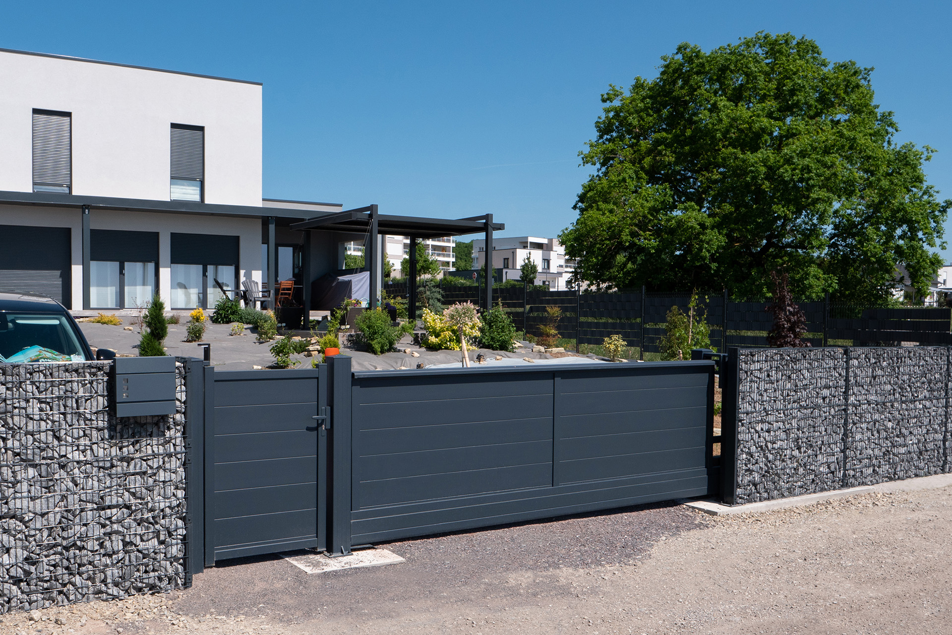 Aménagement d'une résidence individuelle avec clôture gabion et portail aluminium